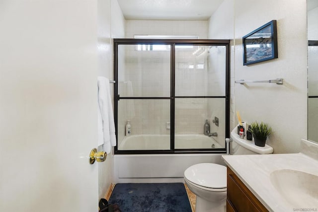 full bathroom with vanity, combined bath / shower with glass door, and toilet