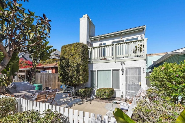 rear view of property with a patio area and a balcony