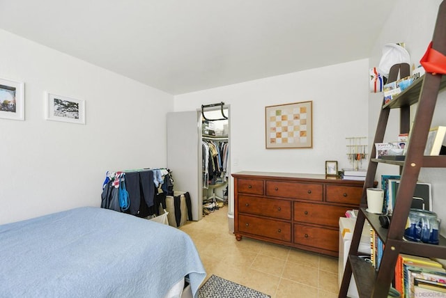 bedroom with a spacious closet, a closet, and light tile patterned flooring