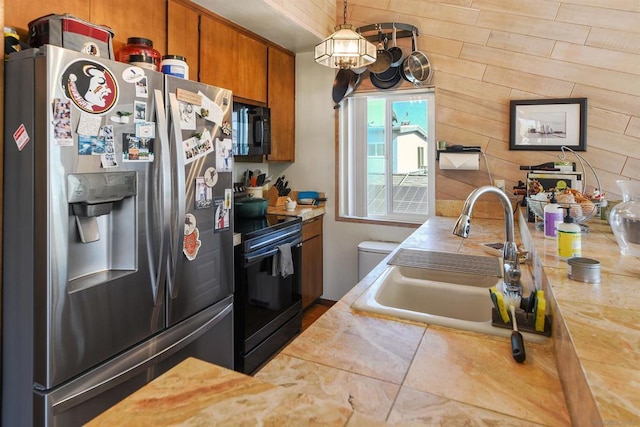 kitchen with hanging light fixtures, sink, and black appliances