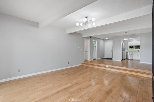 unfurnished living room with beam ceiling, a notable chandelier, and hardwood / wood-style flooring