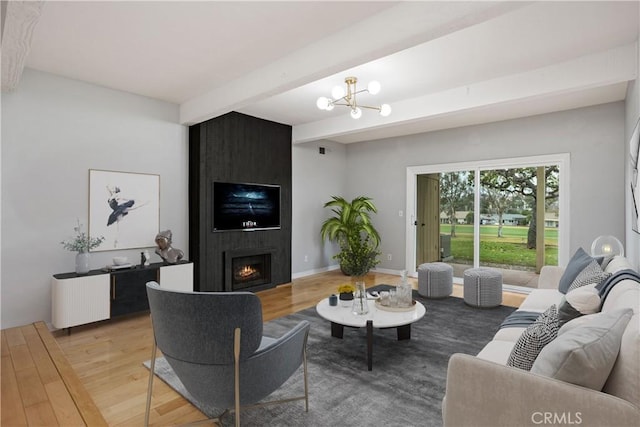 living room with an inviting chandelier, a large fireplace, beam ceiling, and light hardwood / wood-style floors