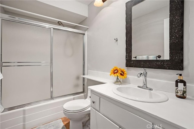 full bathroom with bath / shower combo with glass door, vanity, and toilet