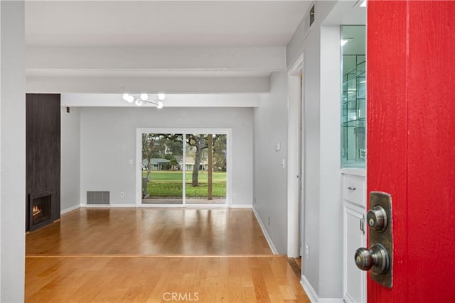 entrance foyer featuring wood-type flooring and a fireplace