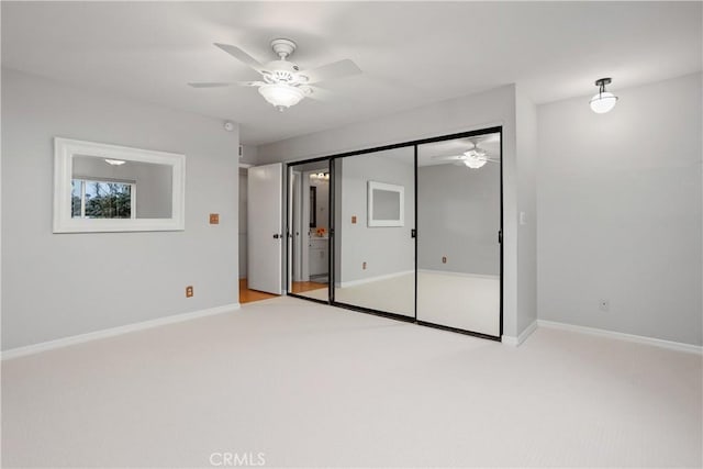 unfurnished bedroom with ceiling fan, light colored carpet, and a closet