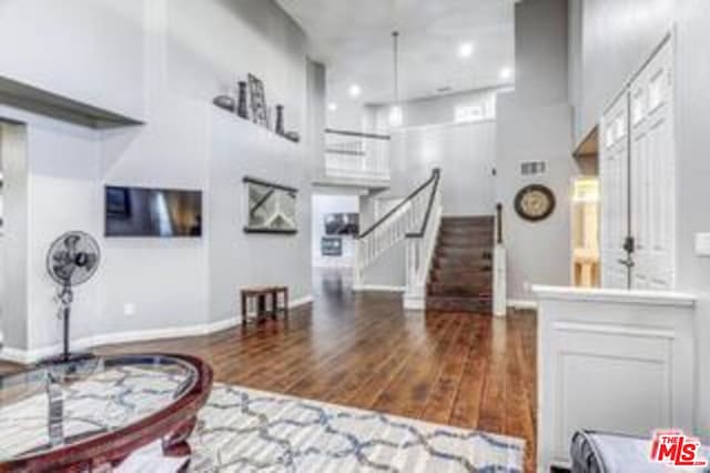 foyer with dark wood-type flooring and a high ceiling