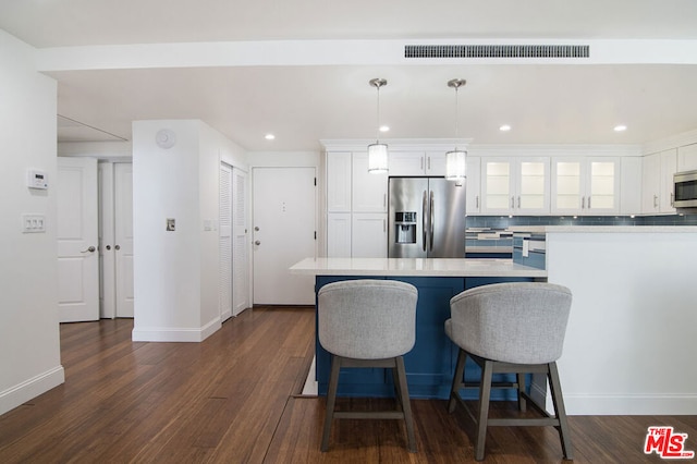 kitchen featuring pendant lighting, stainless steel appliances, tasteful backsplash, white cabinets, and dark hardwood / wood-style flooring