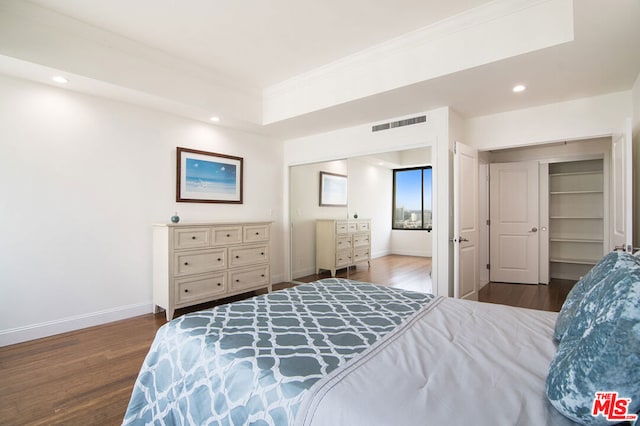 bedroom with ornamental molding and dark hardwood / wood-style flooring