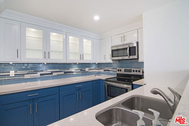 kitchen with blue cabinetry, sink, appliances with stainless steel finishes, white cabinets, and backsplash