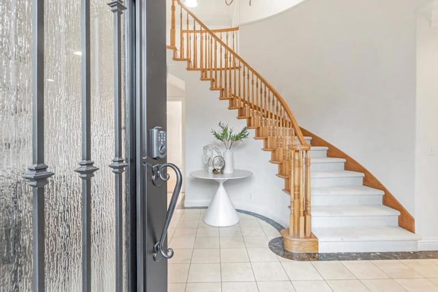 tiled foyer entrance with a towering ceiling