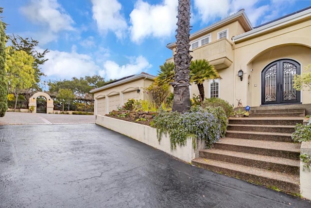 entrance to property featuring a garage and french doors