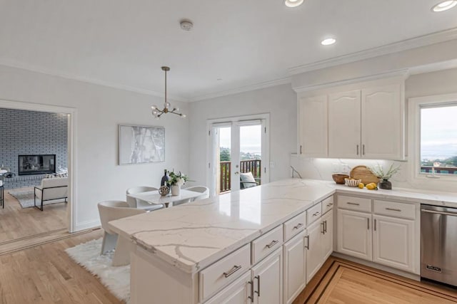 kitchen featuring hanging light fixtures, white cabinetry, stainless steel dishwasher, and kitchen peninsula