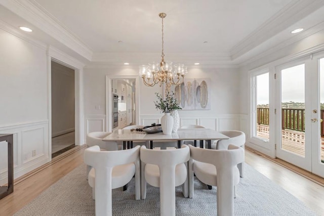 dining area featuring crown molding, a chandelier, and light hardwood / wood-style floors