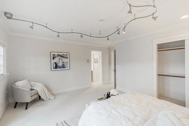 bedroom with crown molding, rail lighting, light colored carpet, and a closet