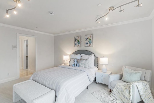 bedroom featuring ornamental molding, rail lighting, and light carpet