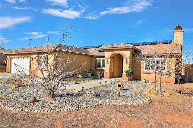 view of front of property featuring a garage and solar panels