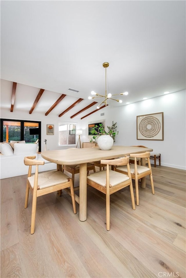 dining space featuring an inviting chandelier, light wood-type flooring, and vaulted ceiling with beams