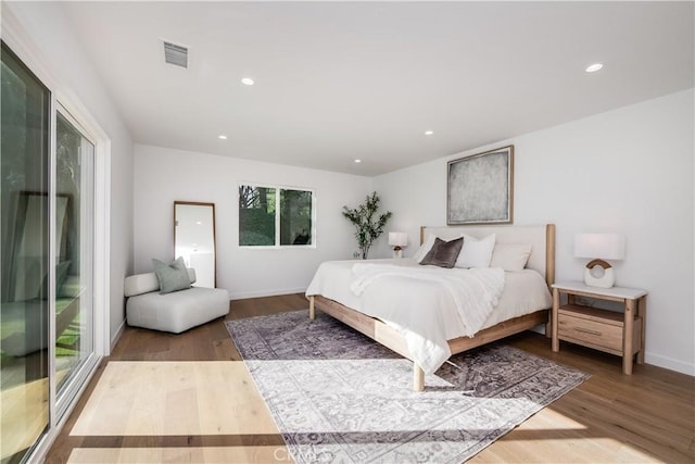 bedroom with wood-type flooring and access to outside