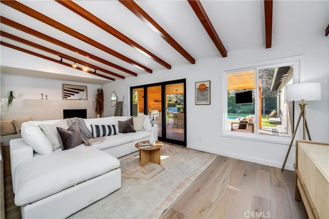 living room with lofted ceiling with beams and light hardwood / wood-style floors