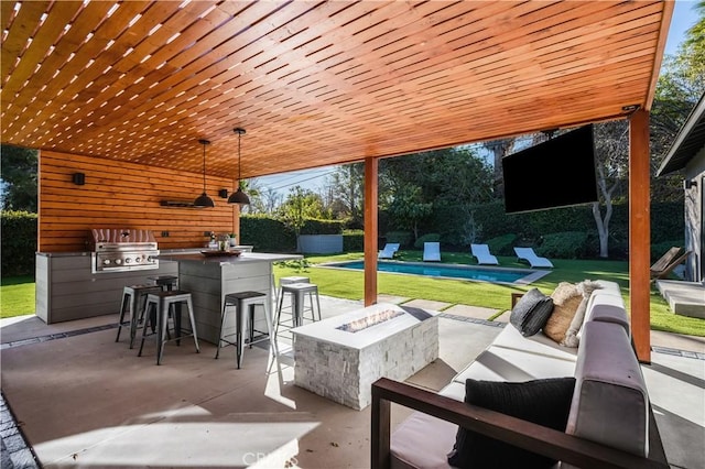 view of patio featuring area for grilling, a grill, an outdoor living space with a fire pit, and an outdoor bar