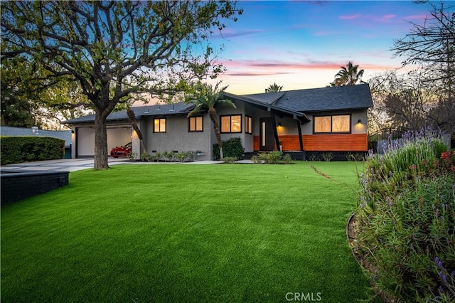 view of front facade with a garage and a lawn