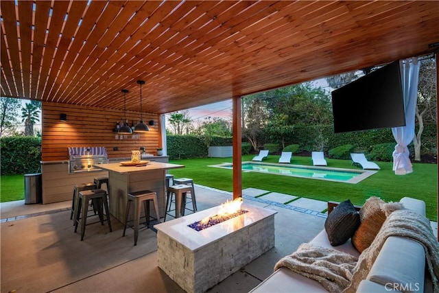 view of patio / terrace with an outdoor bar and a fire pit