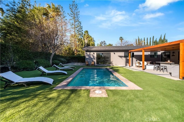 view of swimming pool featuring a lawn, an outdoor bar, and a patio area