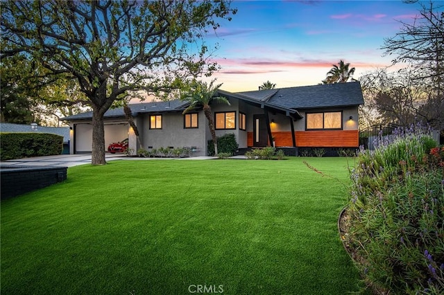 view of front of property featuring a garage and a lawn