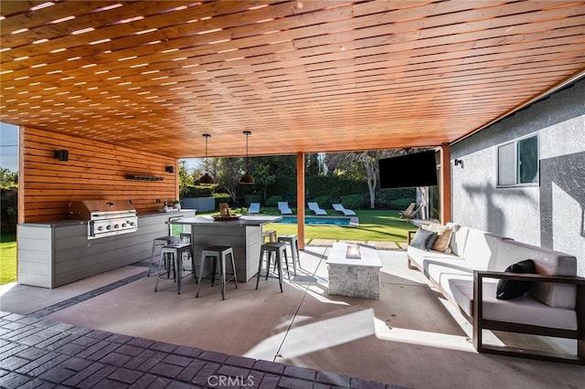 view of patio / terrace with a bar, area for grilling, exterior kitchen, and an outdoor living space with a fire pit