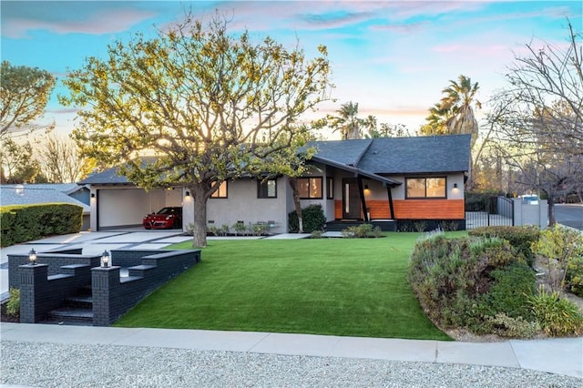 view of front of house featuring a garage and a lawn