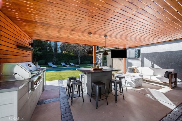 view of patio / terrace featuring area for grilling, an outdoor living space with a fire pit, and an outdoor bar