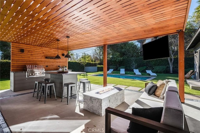 view of patio / terrace featuring a grill, an outdoor kitchen, an outdoor living space with a fire pit, and exterior bar