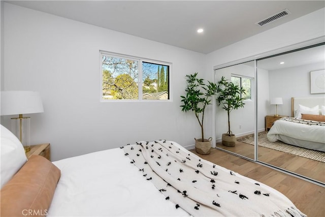 bedroom with wood-type flooring and a closet