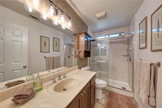 bathroom featuring vanity, toilet, and a shower with shower door