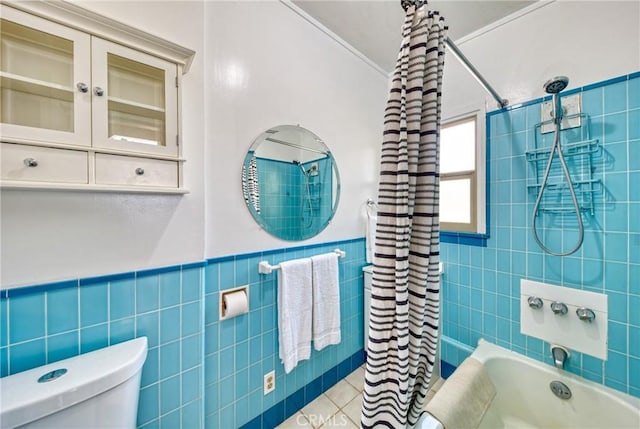 bathroom with shower / tub combo with curtain, tile patterned floors, toilet, and tile walls