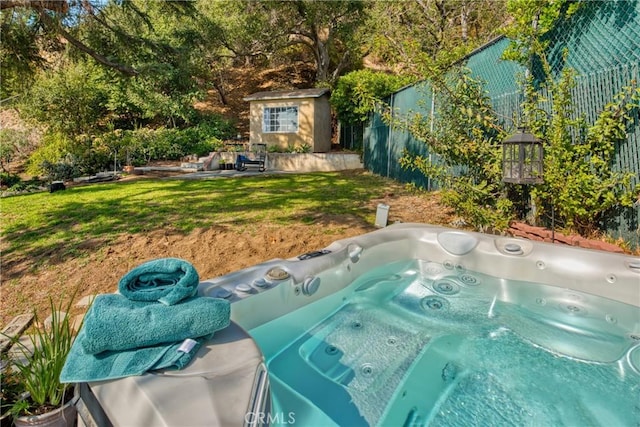 view of swimming pool featuring a yard, a hot tub, and a shed