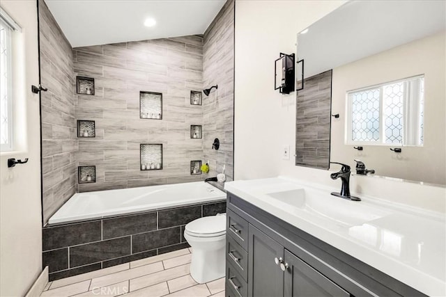 full bathroom with lofted ceiling, vanity, toilet, and tiled shower / bath