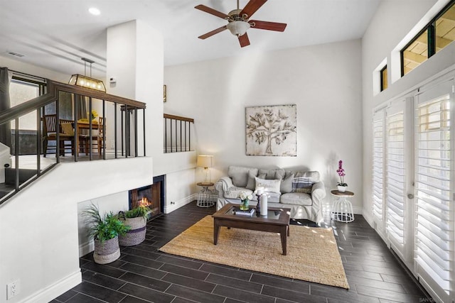 living room with a towering ceiling and ceiling fan