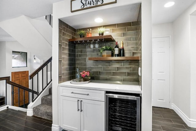 bar featuring wine cooler, decorative backsplash, and white cabinets