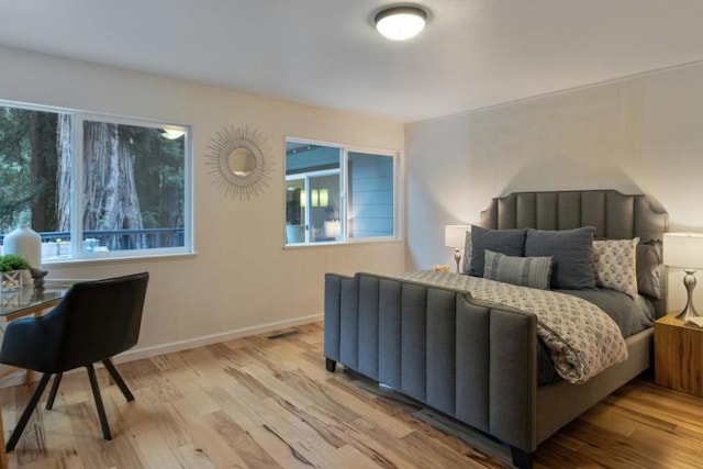 bedroom featuring multiple windows and light hardwood / wood-style floors