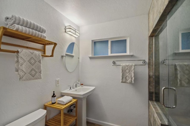 bathroom with toilet and a shower with shower door