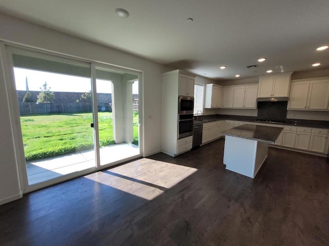 kitchen featuring sink, a center island, appliances with stainless steel finishes, dark hardwood / wood-style floors, and white cabinets