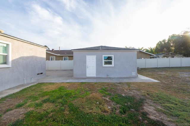 rear view of house with a yard and a patio