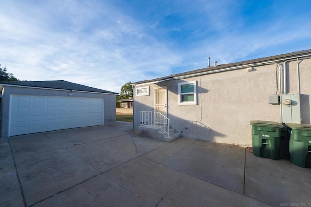 view of side of home featuring a garage and an outbuilding