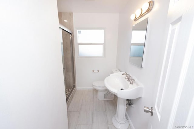 bathroom featuring toilet and a shower with shower door