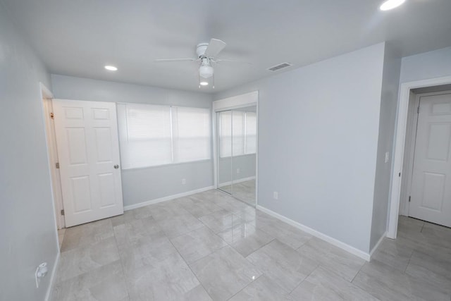 unfurnished bedroom with ceiling fan and a closet