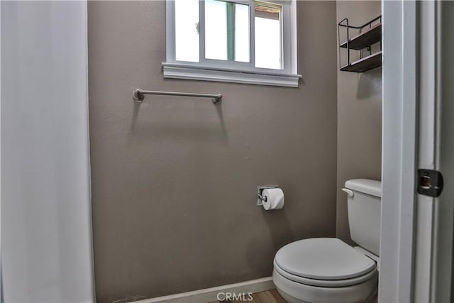 bathroom with toilet and baseboards