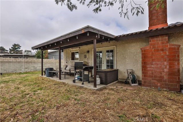 rear view of house featuring a patio, a yard, and french doors