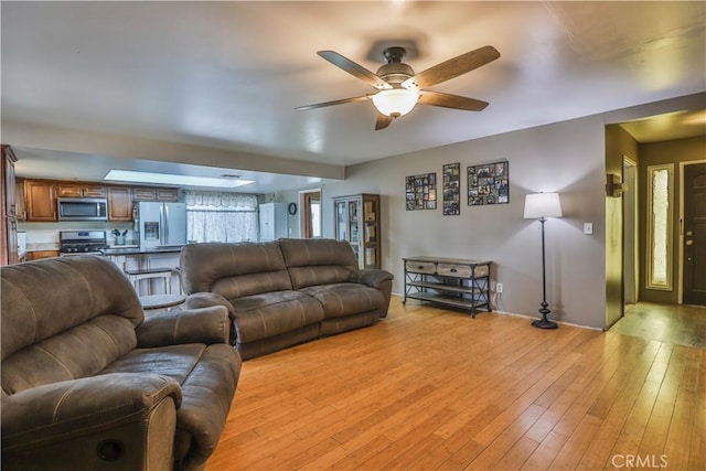 living area featuring a ceiling fan and light wood-style floors