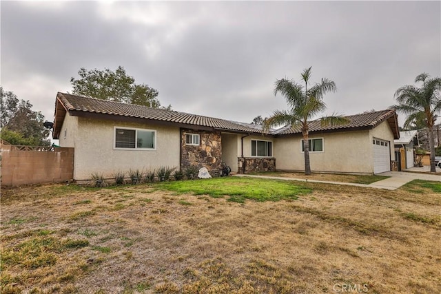 single story home with a garage, a front yard, fence, and stucco siding